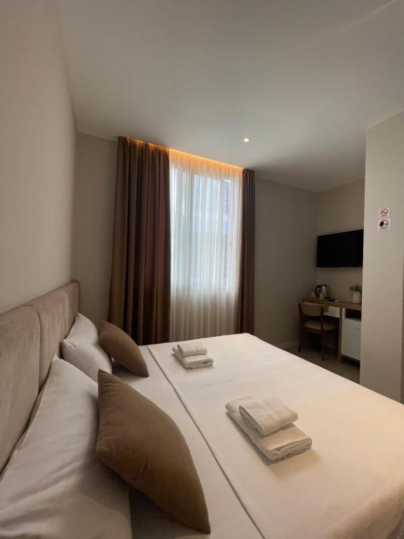 a bedroom with a large bed with two towels on it at Solea Hotel in Vlorë