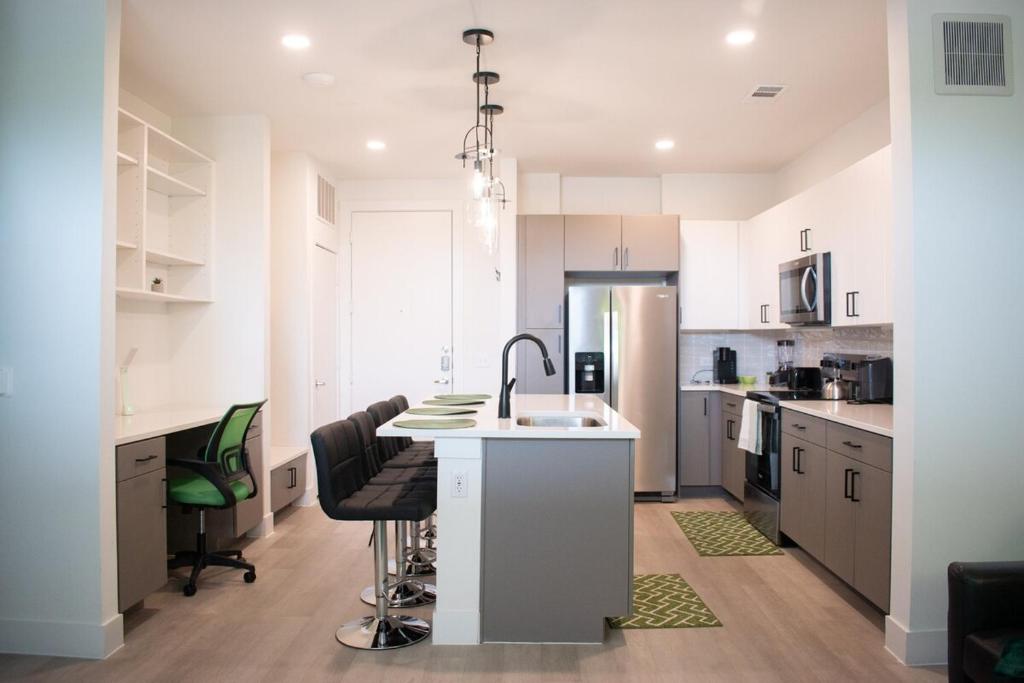 Casita Verde - 10' Domain - WiFi - Free Parking في أوستن: مطبخ بدولاب بيضاء وقمة بيضاء