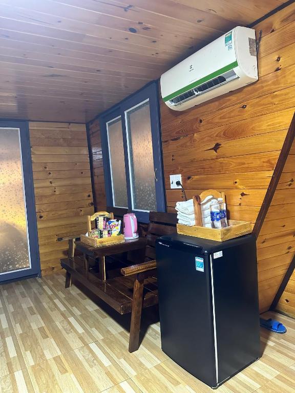 Phú ÐứcにあるHomestay Hồ Senの冷蔵庫、エアコンが備わる客室です。