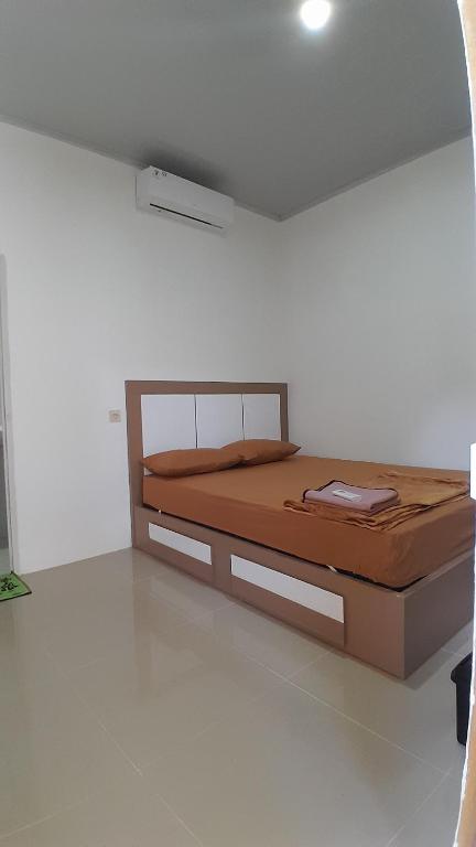 a bedroom with a bed in a white room at Madak ekas homestay 2 in Ekas