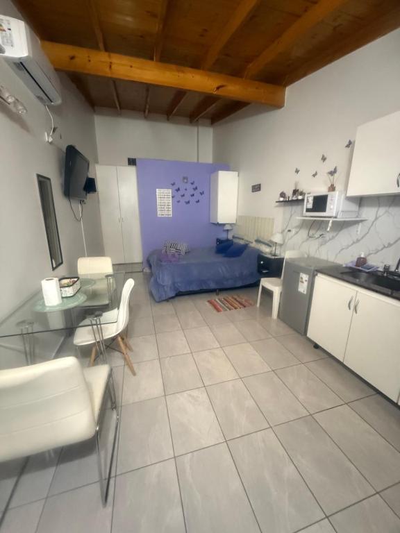 eine Küche und ein Wohnzimmer mit Tisch und Stühlen in der Unterkunft Monoambiente EK Centro Neuquén in Neuquén