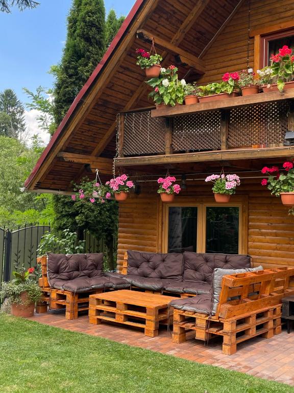 a house with couches and chairs on a deck at Cabana Mistic in Bran
