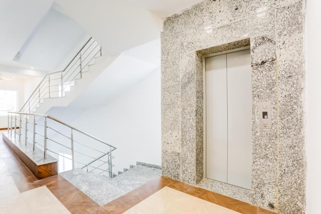una porta bianca in un muro di pietra con scale di Hotel O The Grand Blue Hotel a Noida