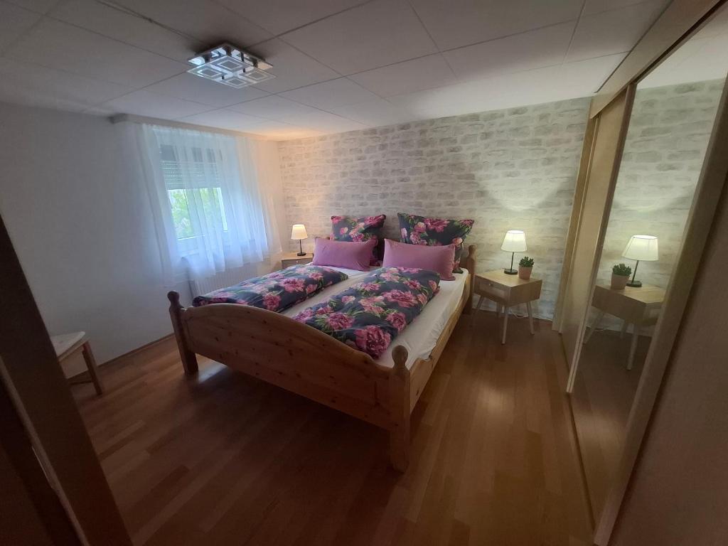 a bedroom with a bed with pink pillows at Ferienwohnung Vey in Hilders