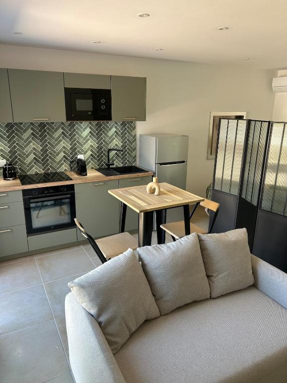a living room with a couch and a kitchen at Le cocon de Malo in Lecci