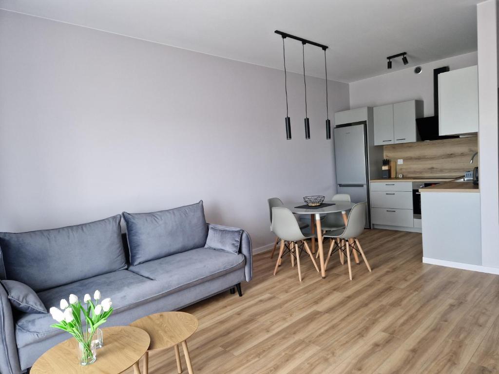 a living room with a blue couch and a table at Apartament ulica Marzeń 13 in Kostrzyn nad Odrą