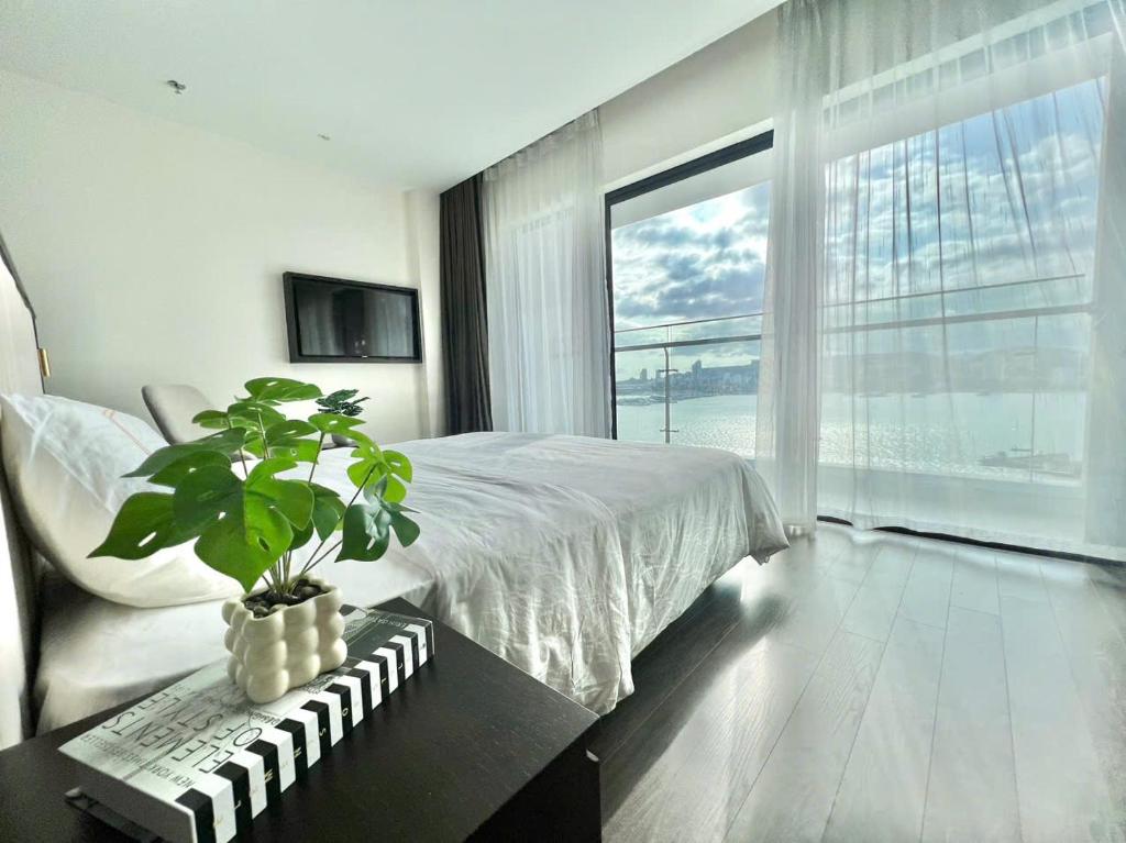 a bedroom with a bed and a plant on a table at Homestay Sapphire Hạ Long in Ha Long