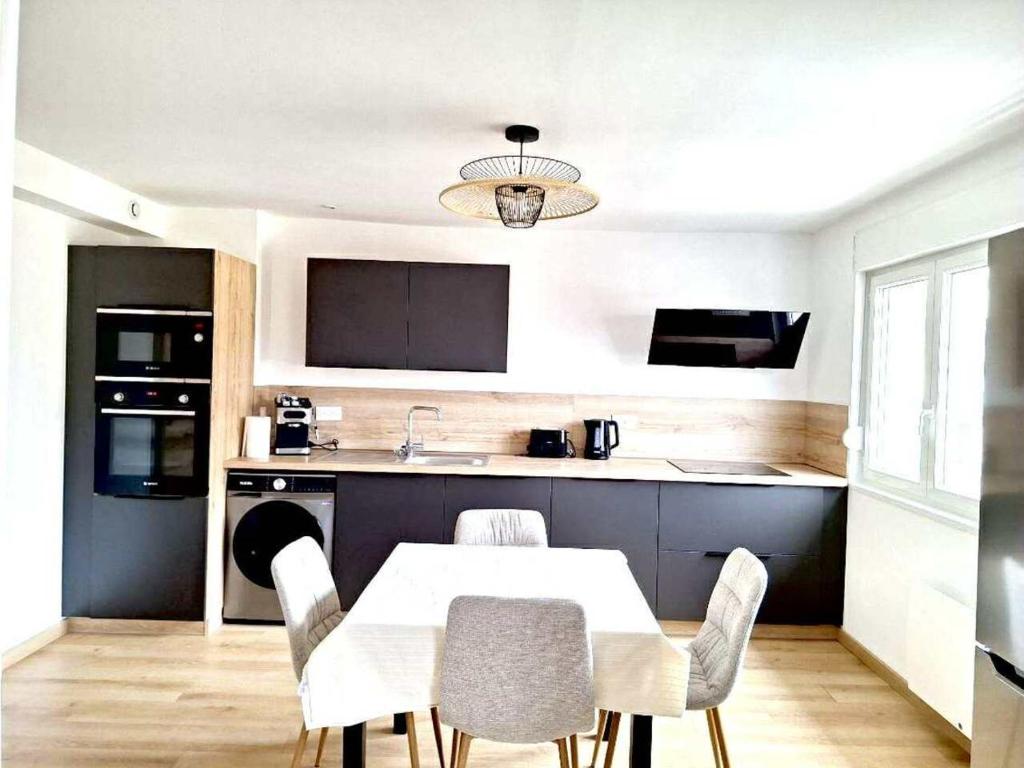 eine Küche mit Tisch und Stühlen in einem Zimmer in der Unterkunft Évasion Marine- plage à 5 minutes a pied in Le Portel