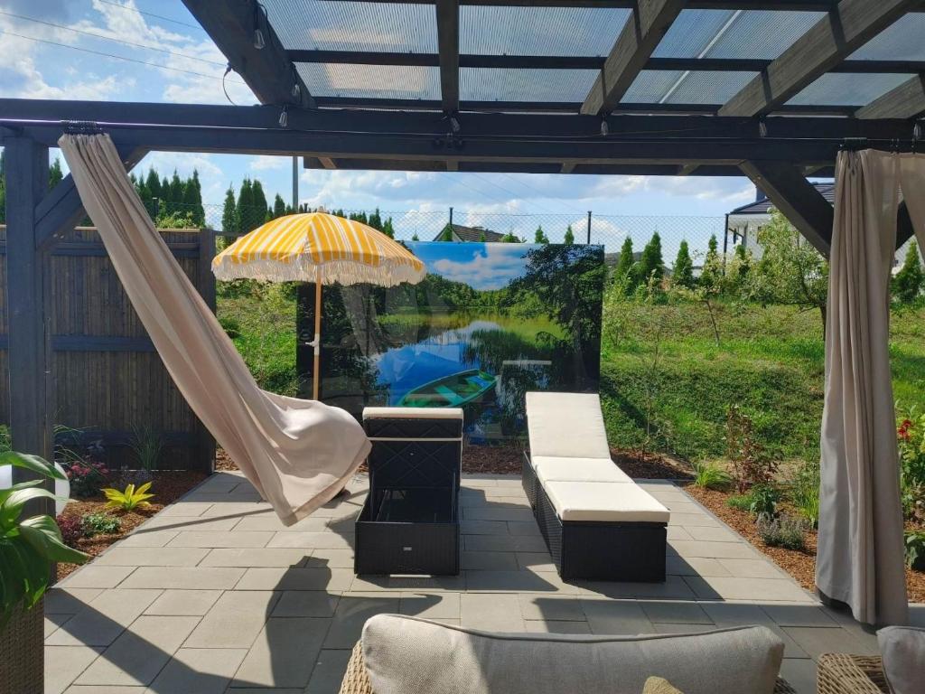 a patio with an umbrella and a bench at Apartament Lipowa 2 in Mrągowo