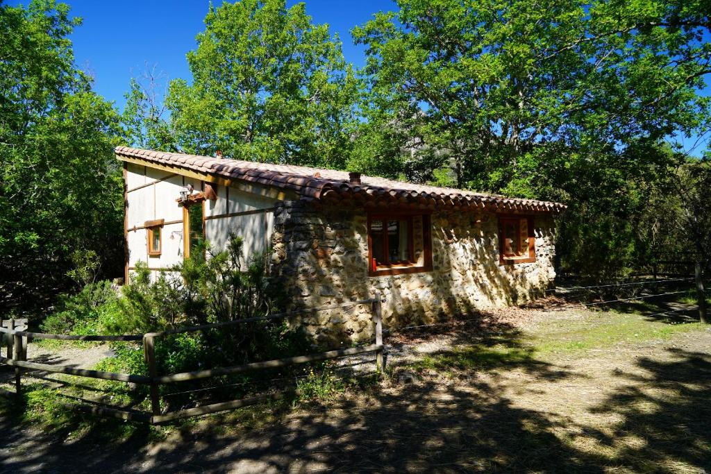 a small stone house in the middle of trees at Gîtes à la Ferme - Hautes-Corbières in Termes
