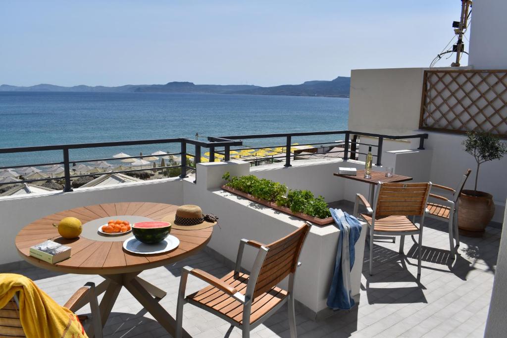 a balcony with a table and chairs and the ocean at Portobelis Apartments in Sitia