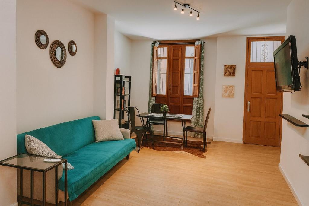 a living room with a green couch and a table at Downtown Valencia in Valencia