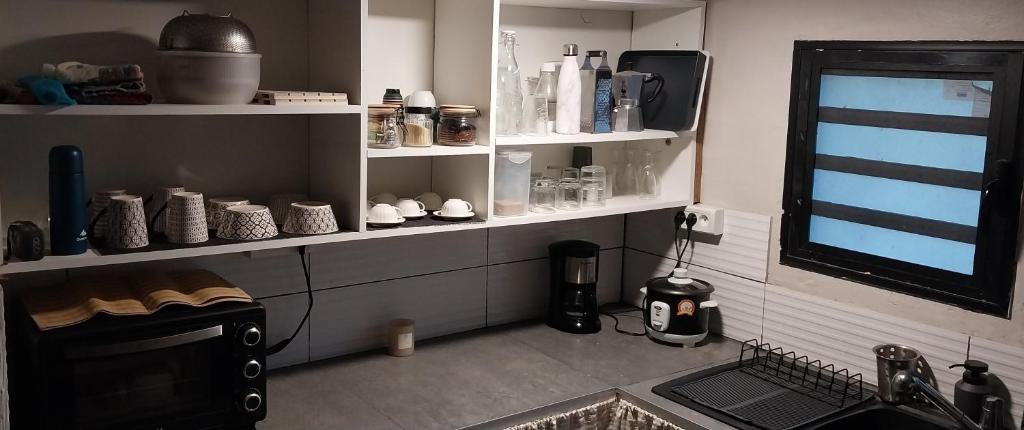 une cuisine avec un comptoir avec des étagères et une fenêtre dans l'établissement Lamézon Entre-deux Location Saisonnière, à Entre-Deux