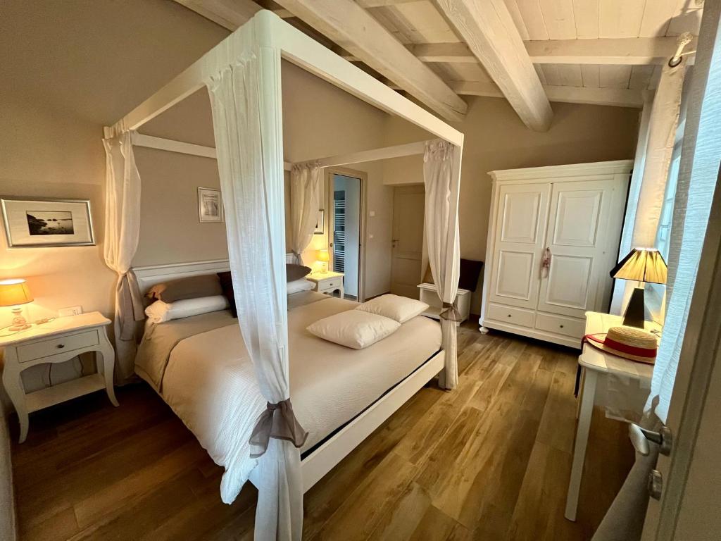 a bedroom with a canopy bed and a wooden floor at Agriturismo Tenuta Il Molino in Quercianella