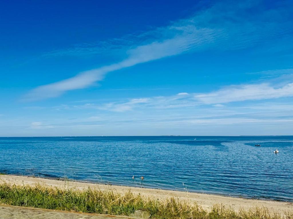 a large body of water with people on a beach at Mobil home 6 à 8 personnes in Piriac-sur-Mer