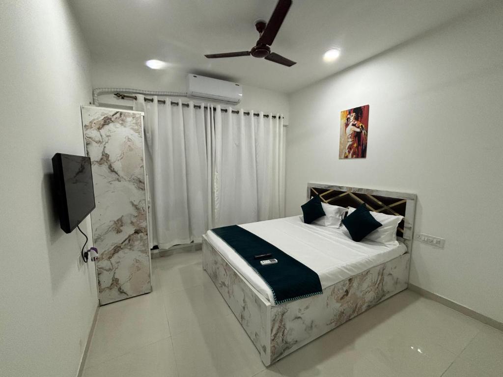 a bedroom with a bed and a ceiling fan at Atithi Homes Luxe Kandivali Suites in Mumbai