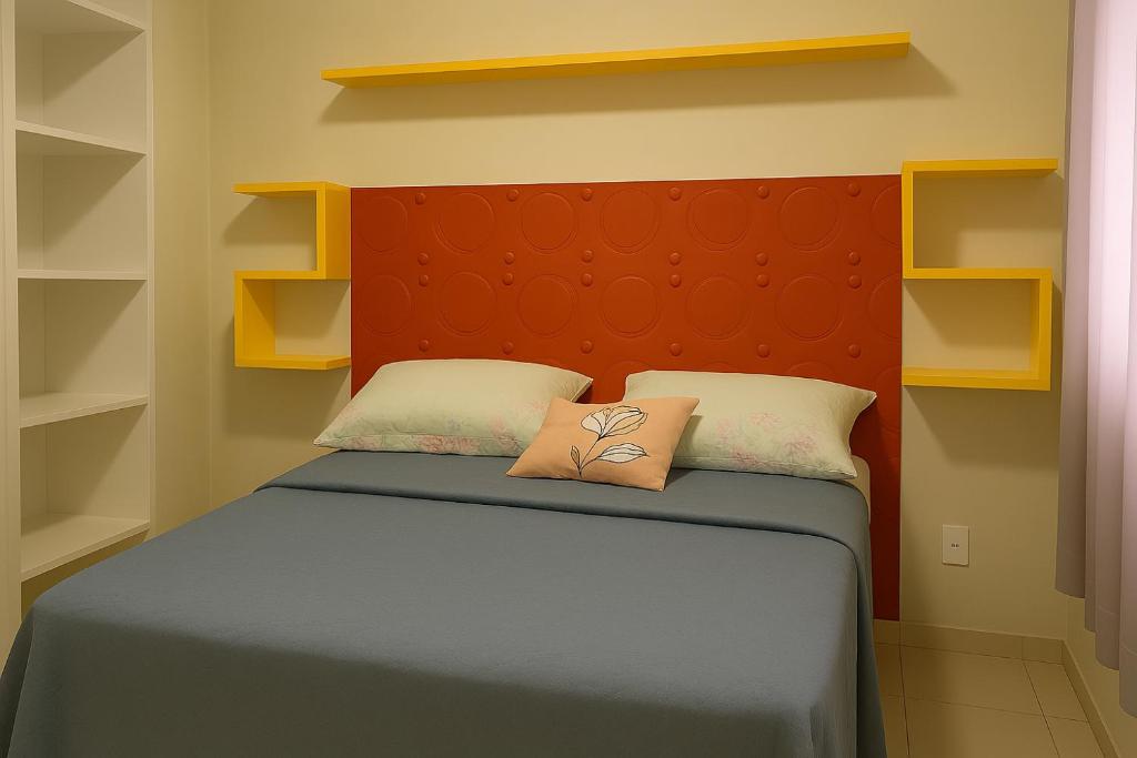 a bedroom with a bed with a orange headboard at Apartamento Cantinho da Cop 30 in Ananindeua
