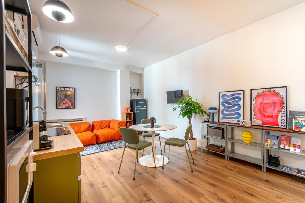 Una sala de estar con un sofá naranja y una mesa. en UM81 - Downtown Apartment, en Trieste