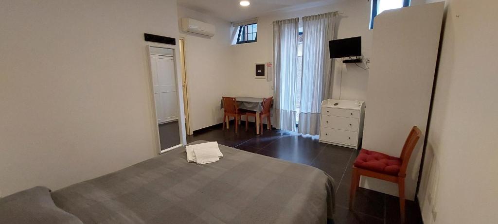 a bedroom with a bed and a table and a chair at Ecoflat Casa Vacanze in Lipari