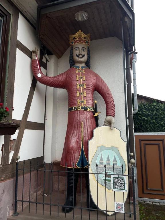 a statue of a man standing next to a building at Ferienwohnungen am Roland in Neustadt