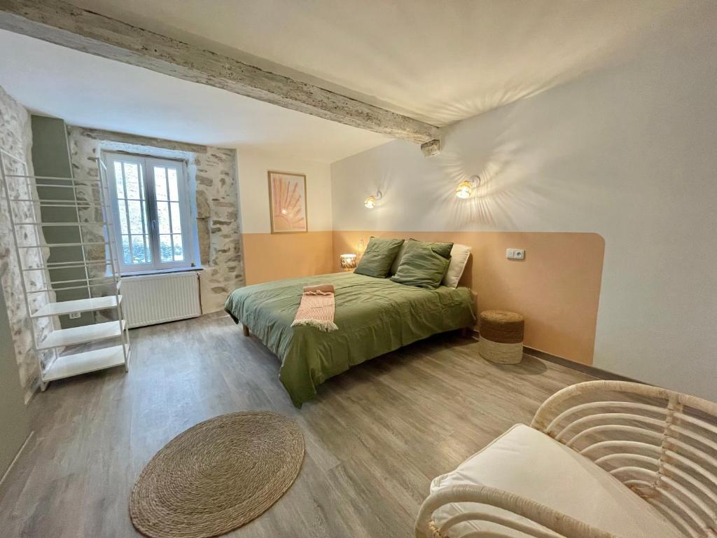 a bedroom with a green bed and a couch at Suites zen dans maison d'hôtes avec piscine intérieure et jardin in Ventenac-Cabardès