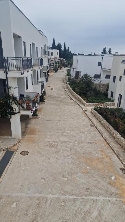 an empty street with white buildings on the side at Apartament , White Rocks, Drimadhe in Himare
