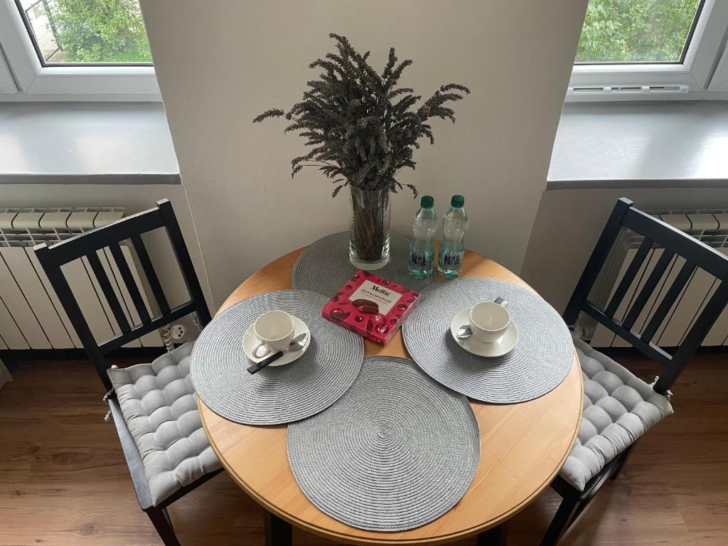 a wooden table with two hats and a vase on it at Cherry Apart Legionów 24 in Łódź