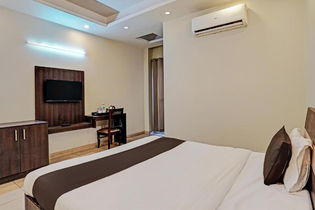 a bedroom with a large bed and a television at Townhouse Akshay Hotel in Gurgaon