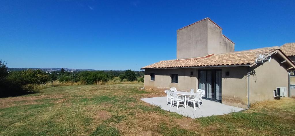 una mesa y sillas sentadas fuera de un edificio en Le Pigeonnier, en Puygouzon-et-Montsalvy