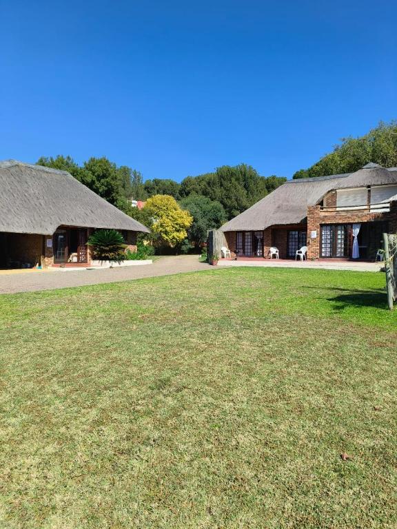 two large buildings with a grass field in front at African Shore Guesthouse in Denysville
