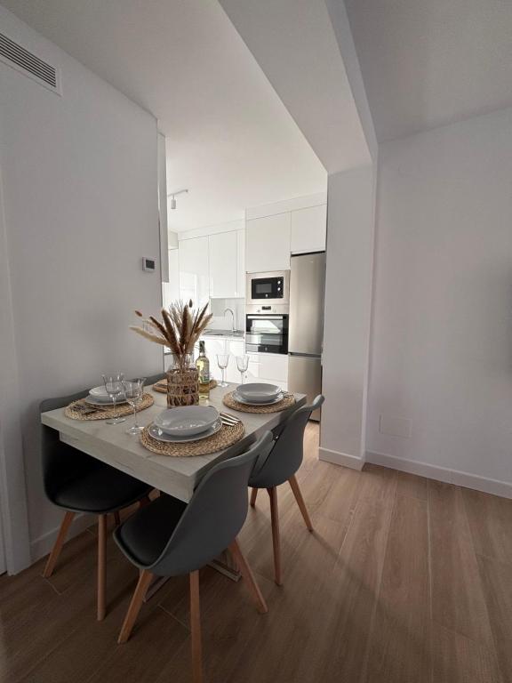 a dining room with a table and chairs and a kitchen at Apartamento García in Nerja