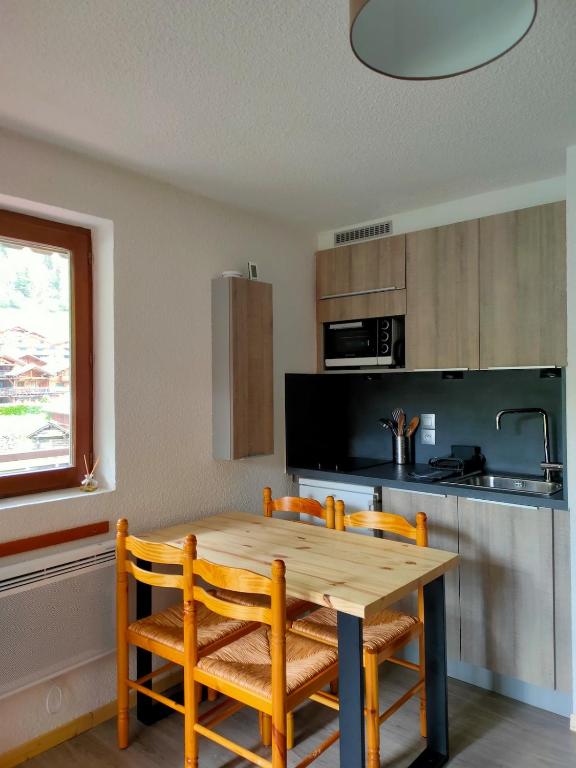 a kitchen with a wooden table and four chairs at Studio Châtel Secteur Linga Proche Pistes in Châtel
