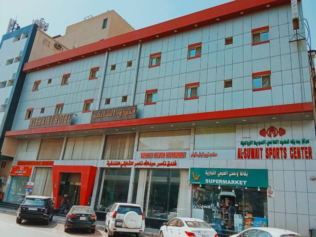 a building with cars parked in front of it at Al Shaiki Hotel in Al Jubail