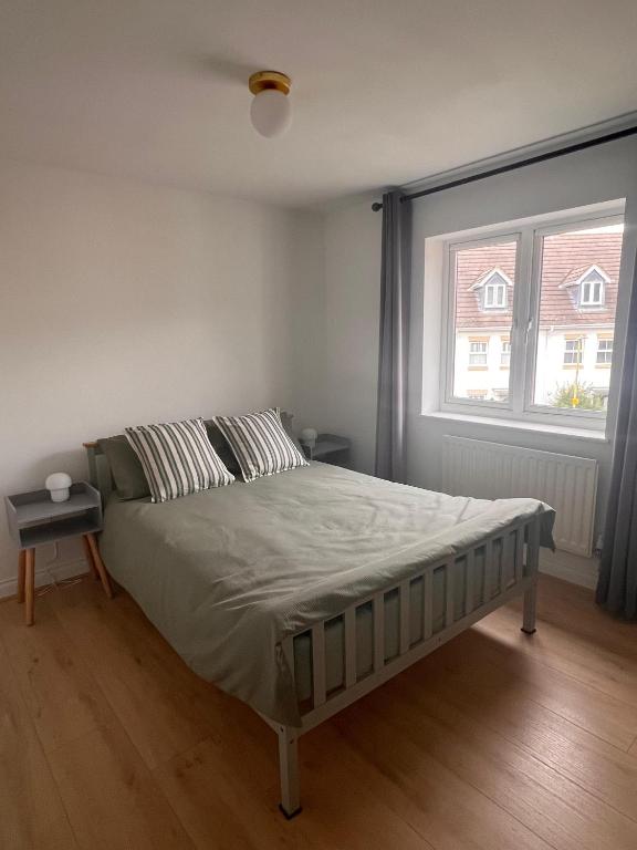 a bed in a bedroom with a large window at La CAZA Guest House in Royston