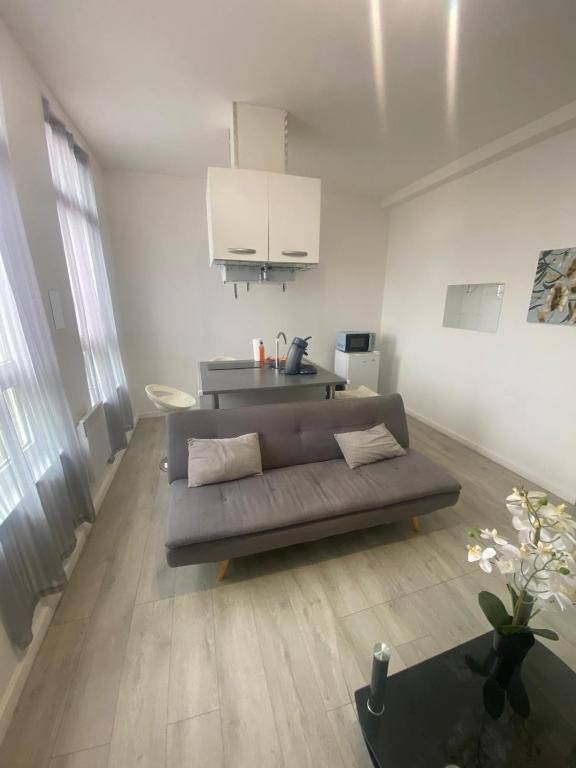 a living room with a couch and a kitchen at LaVIVA 1er in Calais