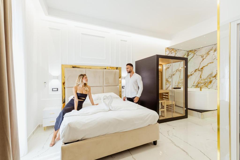 ナポリにあるDove Dormire a Napoli New Opening 2025のホテルの部屋のベッドに座っている男女