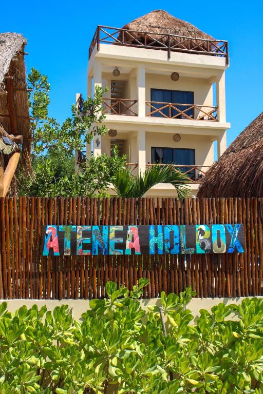 a sign on a fence in front of a house at Atenea 3 private bedrooms in Holbox Island