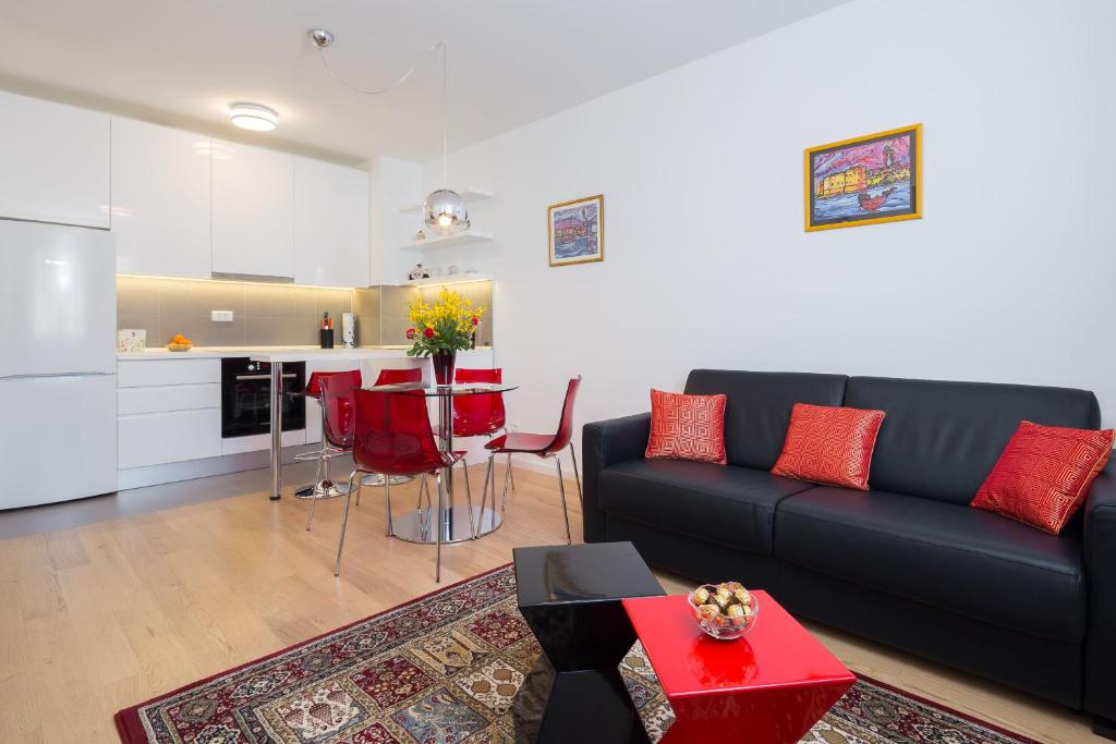 un soggiorno con divano nero e una cucina di Apartment Vjera - garage and elevator a Spalato (Split)