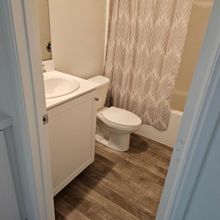 a bathroom with a toilet sink and a shower curtain at Menifee, CA in Menifee