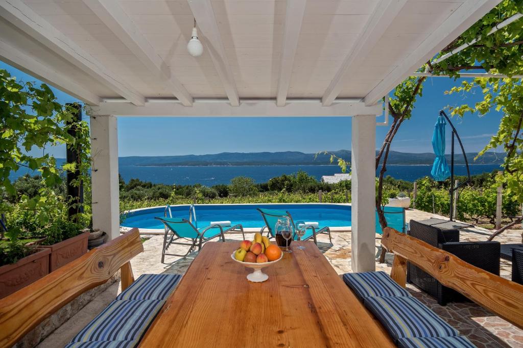 a wooden table with a bowl of fruit on a patio at Holiday Home Vineyard House in Bol