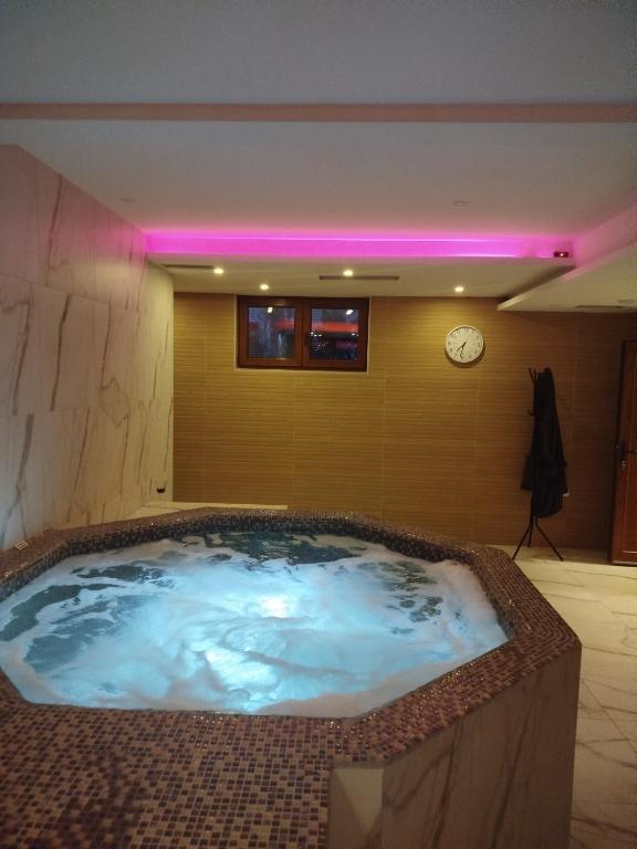 a large hot tub in a room with a clock at STUDIO 33 Luxury&Spa in Zlatibor