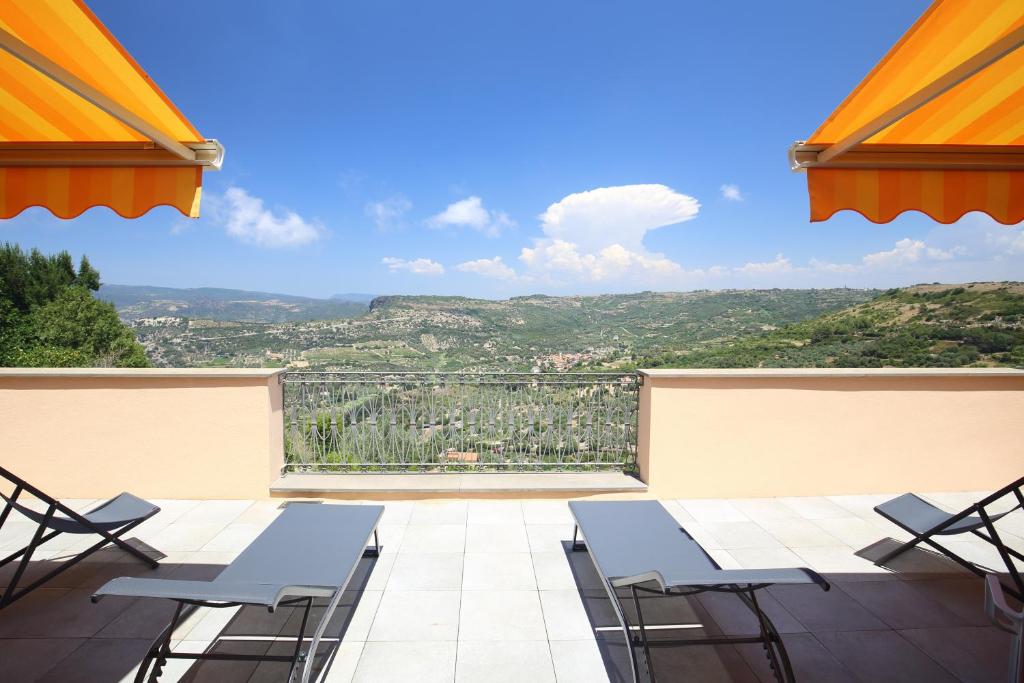 a balcony with chairs and a view of the mountains at Le Terrazze della Planargia B&B in Magomadas
