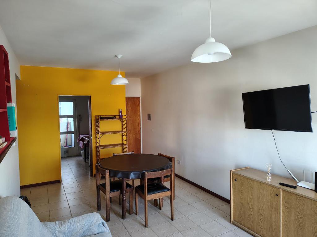 a living room with a table and a tv on a wall at Dpto Saavedra Santa Fe in Santa Fe