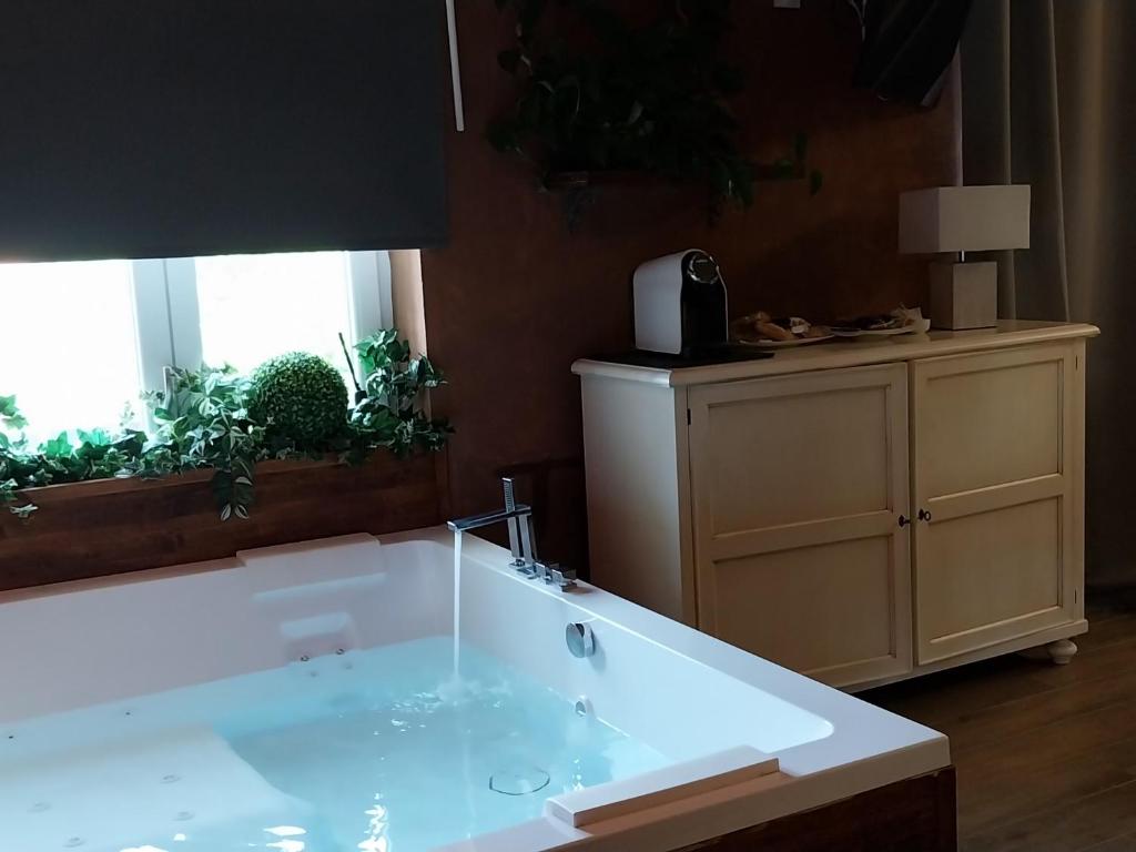 a bathroom with a bath tub with a sink at Boutique Relais Villa Sofia in Gaiole in Chianti