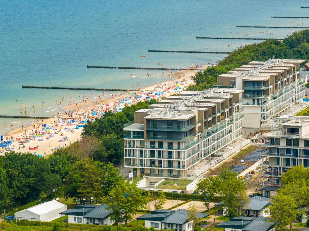シャノジェンティにあるPalermo 104 przy plaży - Perłowa Przystań - Holiday Cityのビーチパラソルと建物がたくさんあるビーチ