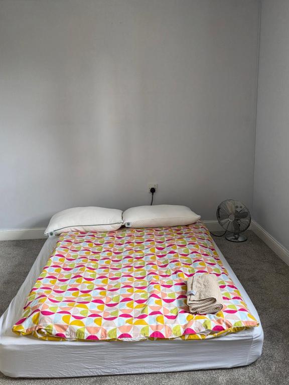 a bed with a colorful blanket on top of it at Stay Near Colchester twn centre3 in Hythe