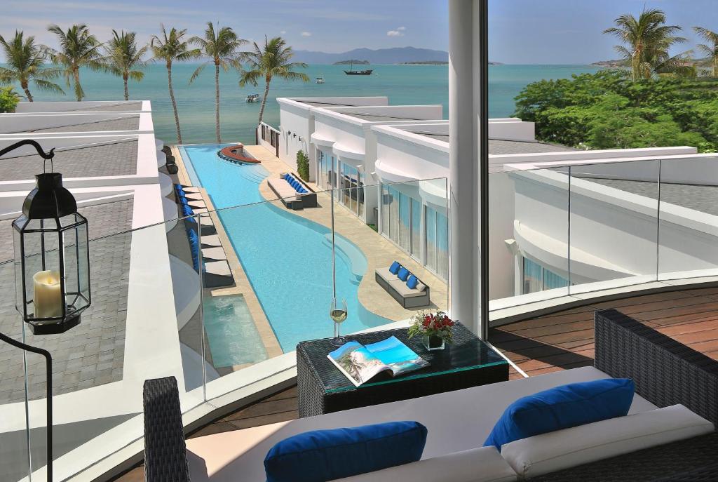 a view of a resort with a swimming pool and the ocean at The Privilege Hotel Ezra Beach Club in Bang Rak Beach