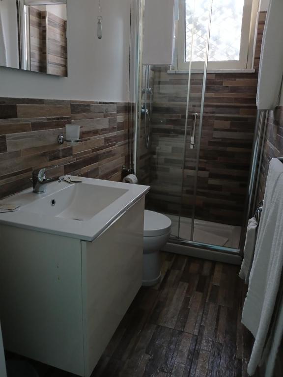 ein Badezimmer mit Waschbecken, Toilette und Dusche in der Unterkunft Maison Martina in Giardini-Naxos