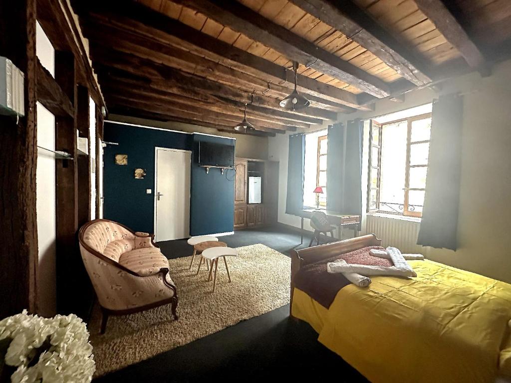 a bedroom with a bed and a chair at Les nuits calmes in La Châtre