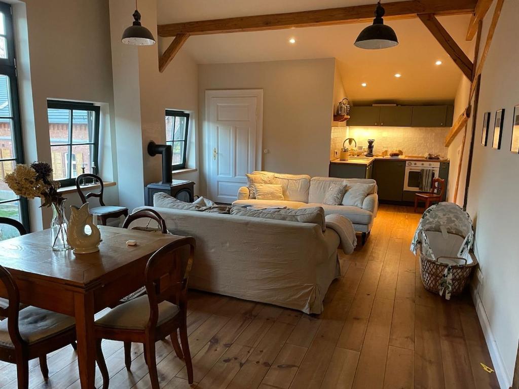 a living room with a couch and a table at Stylish Loft Apartment on a Country Farm in Bad Fallingbostel